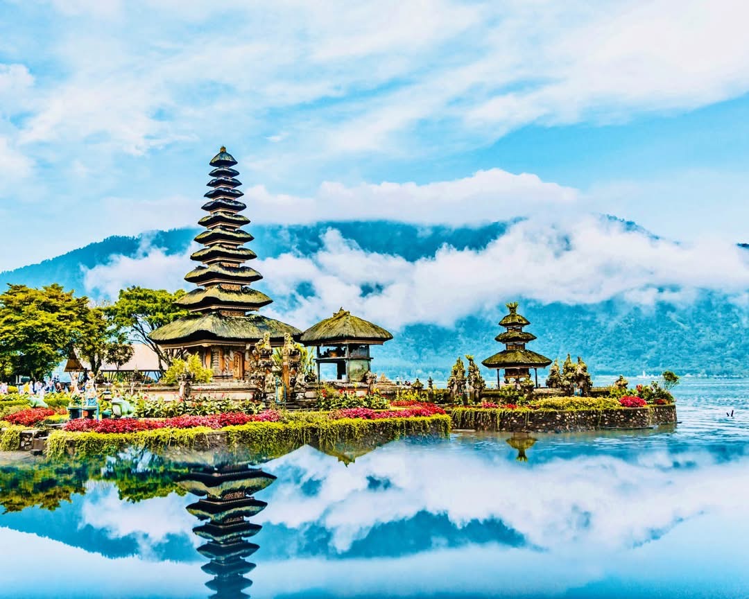 A many-tiered Balinese temple shrine and its reflection on a mountain lake, Bali