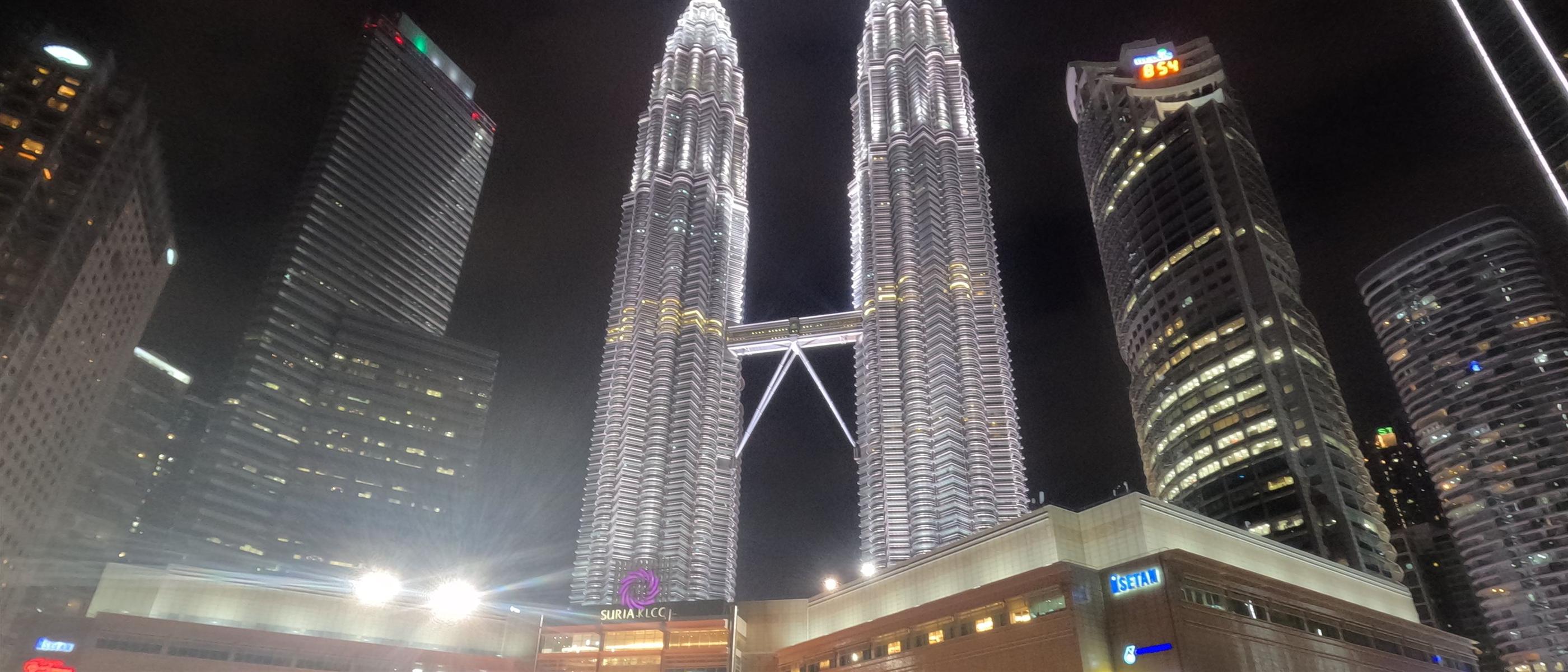 The Petronas Twin Towers lit up above Suria KLCC and the Kuala Lumpur skyline at night, Malaysia