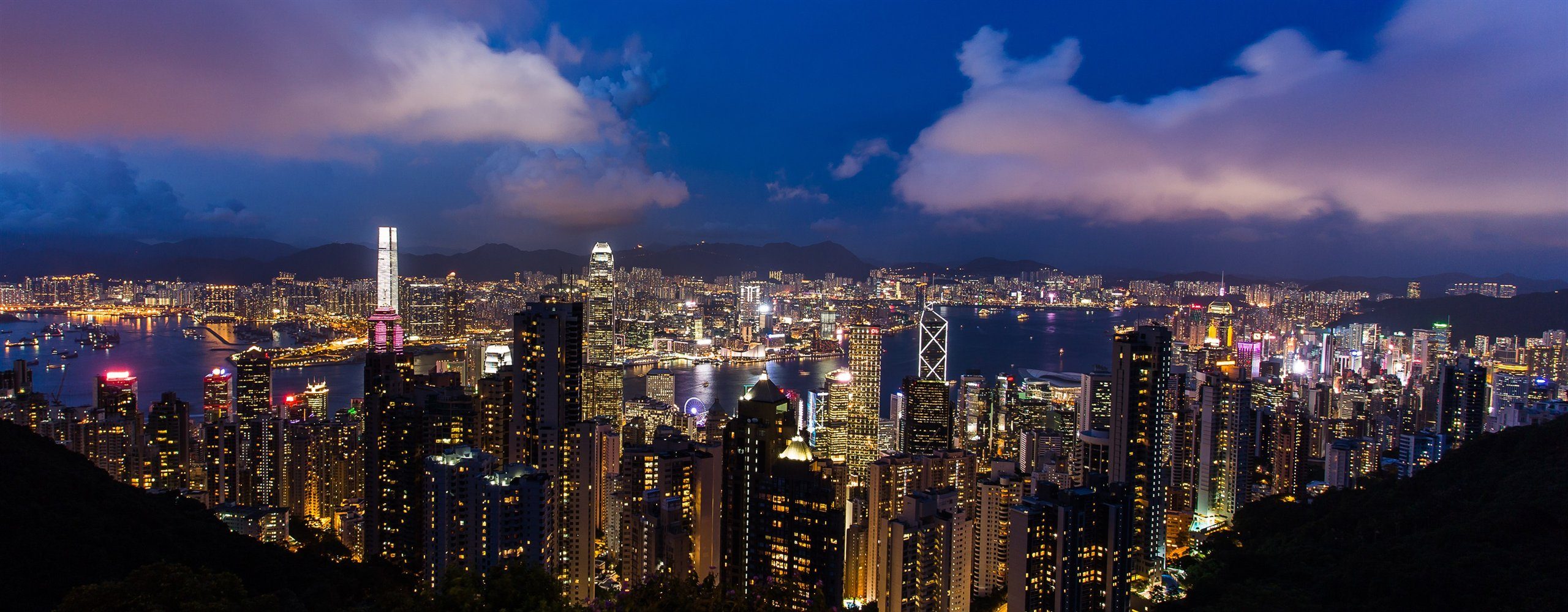 Victoria Harbour and the Hong Kong skyline lit up at blue hour, seen from Victoria Peak, Hong Kong