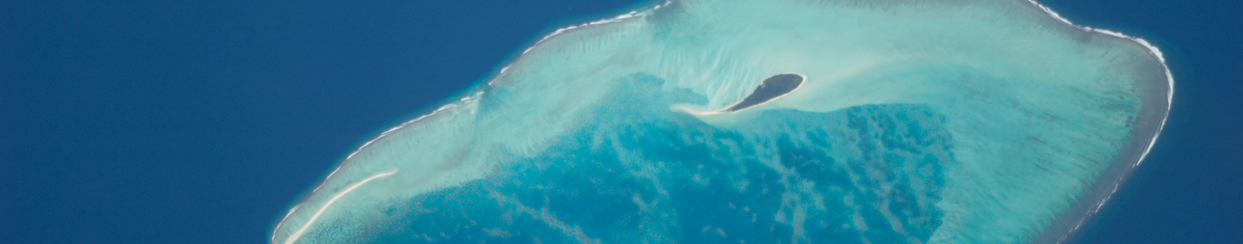 Satellite view of a Lakshadweep atoll, its turquoise lagoon and reef ringed by deep blue ocean