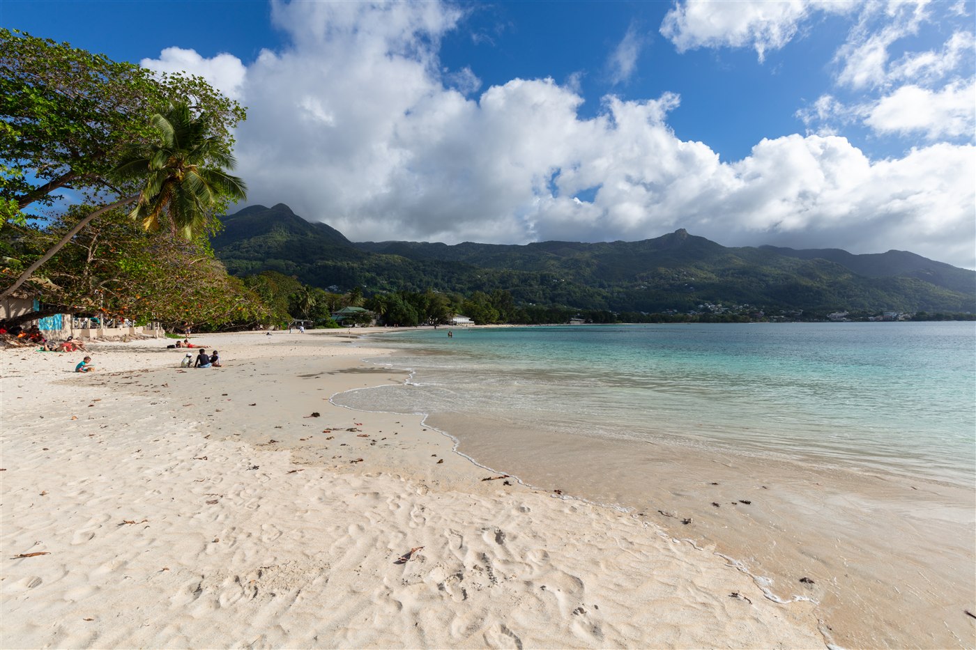 White sand and calm water at Beau Vallon beach with green mountains behind, Mahé, Seychelles