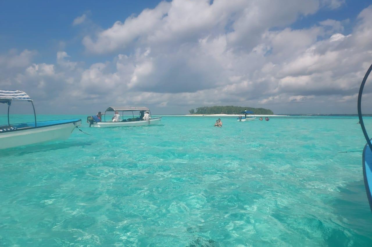 Boats at anchor on a shallow turquoise lagoon under a big sky, Zanzibar