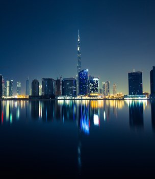 Dubai skyline with the Burj Khalifa reflected in the water at night