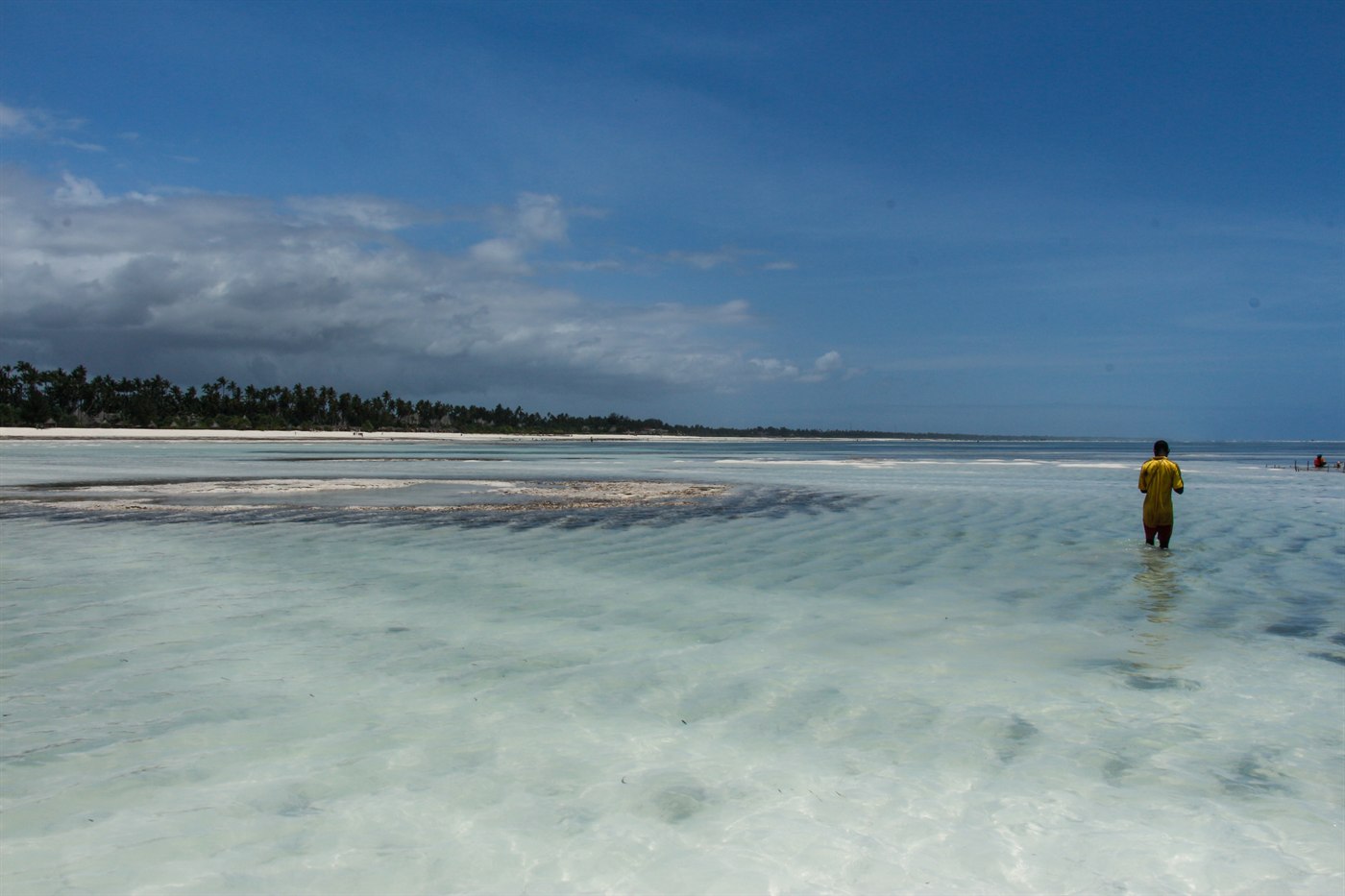 Clear turquoise shallows and white sand at low tide on Zanzibar's east coast, Tanzania
